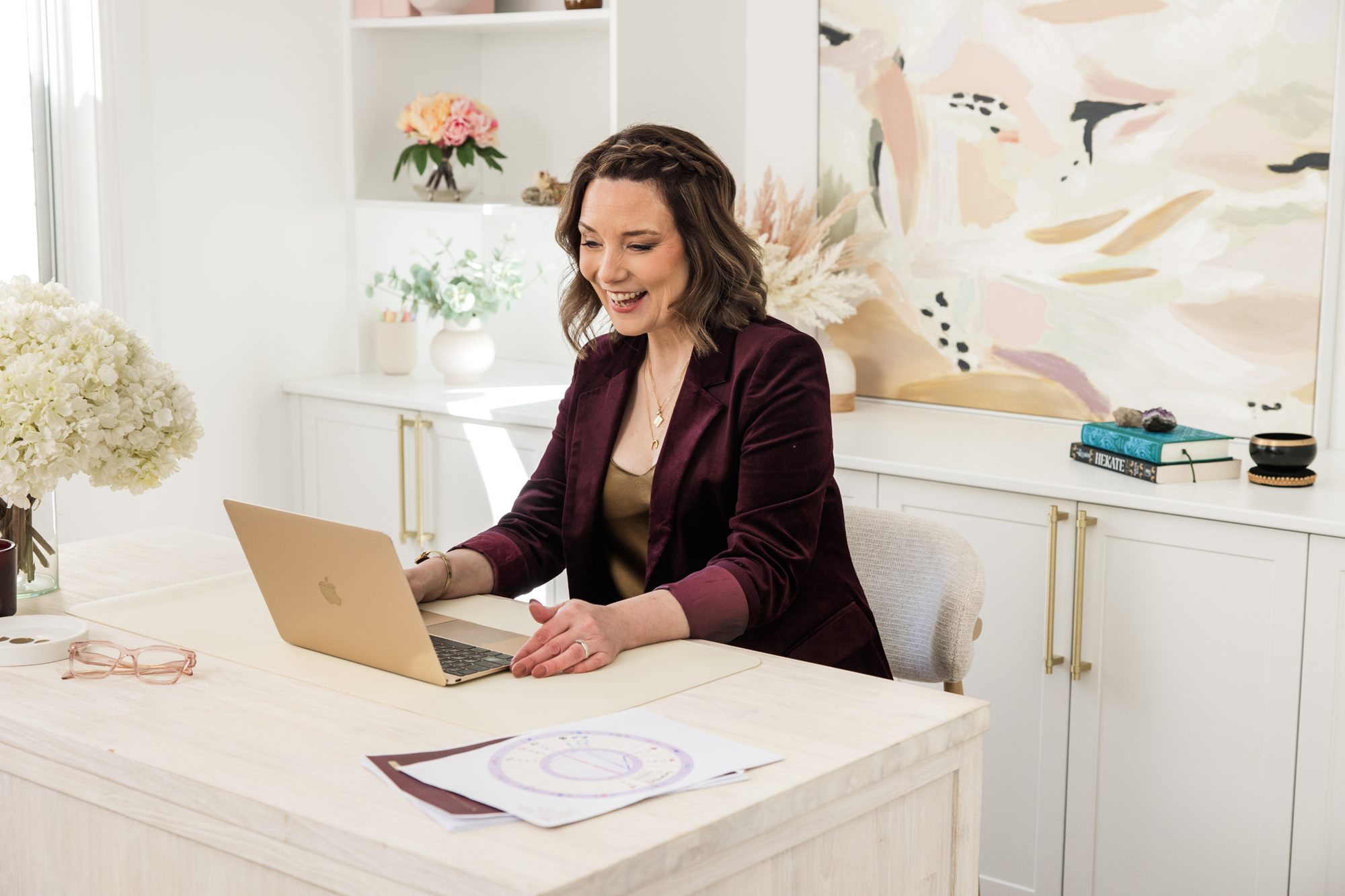 Kathryn Hocking at her desk with a client chart and laptop
